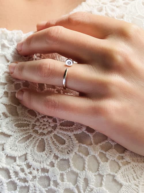 Gros plan main de femme avec la bague Ava ouverte en forme de clou avec un zircon