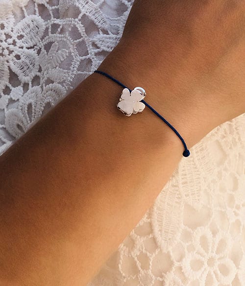 Gros plan poignet de femme avec le bracelet cordon Ange avec un ange coulissant en argent