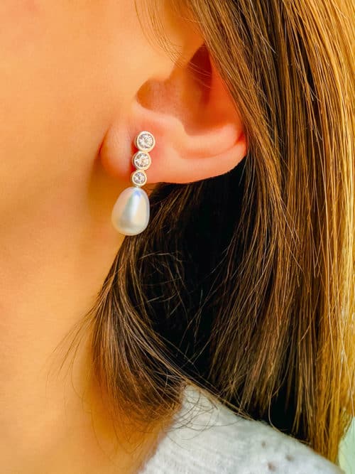Gros plan visage de femme avec boucles d'oreilles Célia en argent, perle et zircons