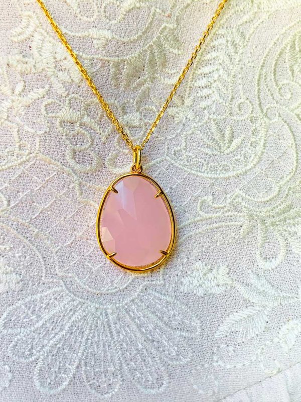 Vue de face très gros plan le collier Maelys en plaqué or avec une grosse pierre semi précieuse ovale en quartz rose
