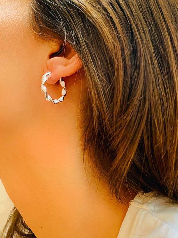 Vue de profil gros plan oreille avec les boucles d'oreille Tania style créole en argent avec effet torsadé