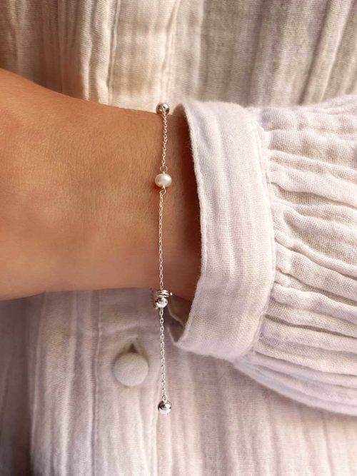Vue de face gros plan poignet femme avec un bracelet chaîne avec des perles et des perles en argent