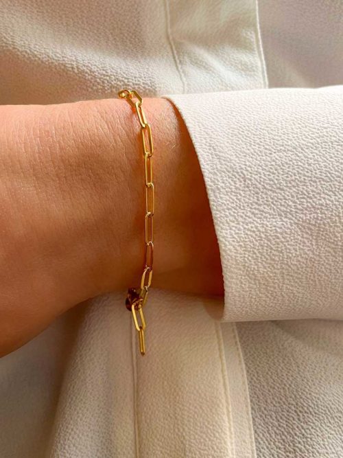 Gros plan poignet de femme avec le bracelet Léna Doré avec une chaîne en plaqué or avec de gros maillons rectangulaires