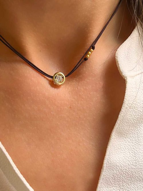 Gros plan cou de femme avec le collier cordon Joan Doré avec un zircon cerclé de plaqué or. bijoux fantaisies en plaqué or