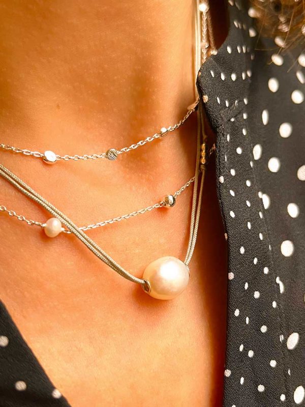 Gros plan cou avec les 3 colliers Apolline Joséphin et Emilie mélangeant les perles, les plaques rondes martelées en argent. Trio de bijoux fantaisies