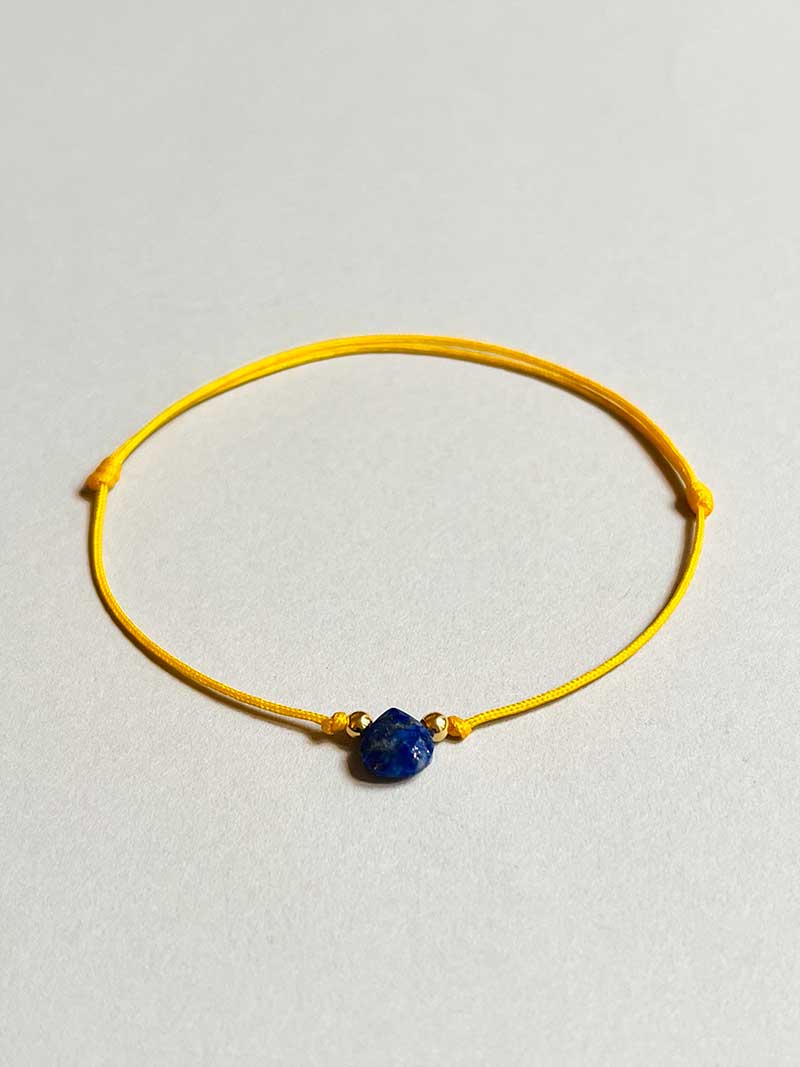 Gros plan bracelet cordon pierre semi précieuse lapis lazuli perles plaqué or