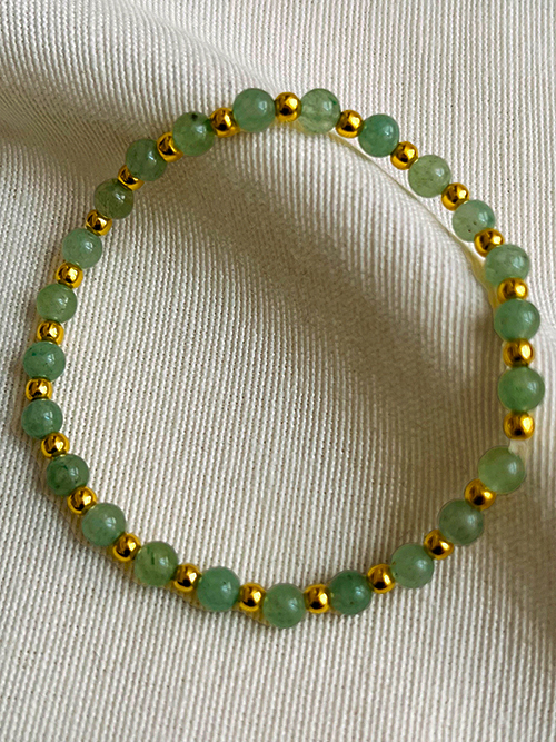 Gros plan bracelets perles pierre naturelle aventurine plaqué or