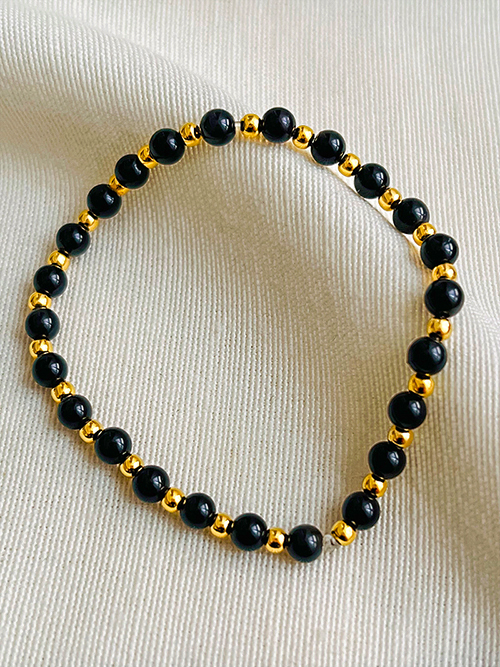 Gros plan bracelets pierres naturelles perles obsidienne plaqué or