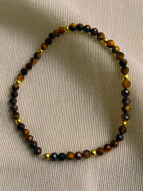 Gros plan bracelets pierres naturelles perles oeil de tigre plaqué or
