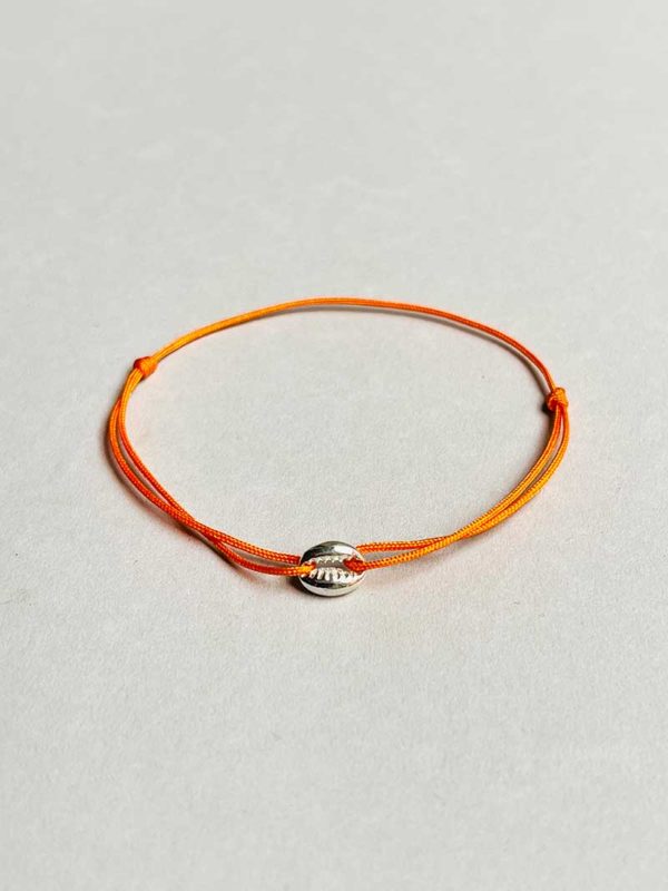 Gros plan posé devant un fond blanc le bracelet cordon Coquillage avec un coquillage en argent et un cordon orange