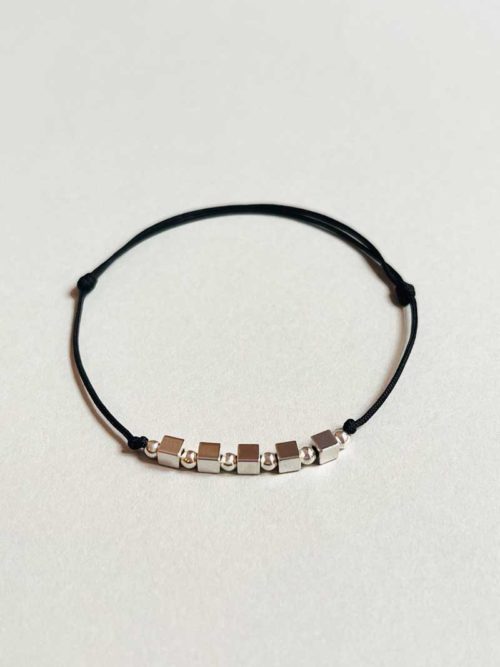 Gros plan bracelet cordon cube perles argent