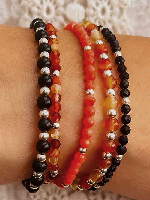 Gros plan bracelet élastique perles pierres naturelles cornaline onyx bambou de mer obsidienne argent