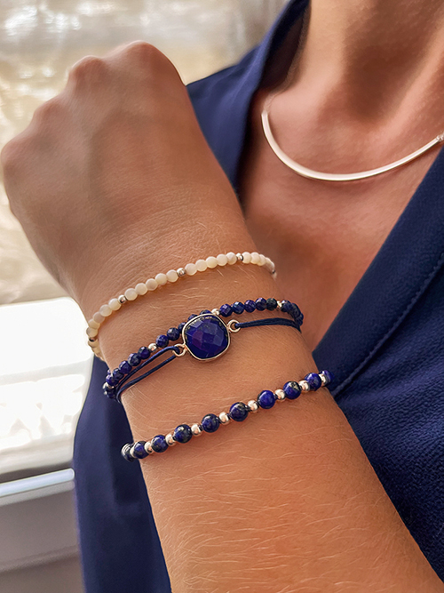 Gros plan bracelets cordon et élastique pierres naturelles perles Lapis-Lazuli nacre argent collier barre courbée