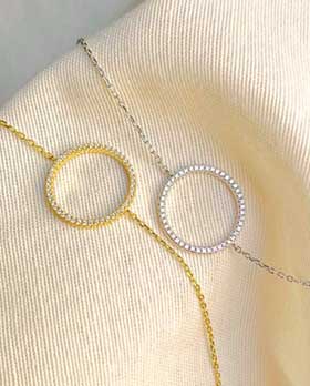 Gros plan deux bracelet chaînes avec un cercle recouvert de zircons en argent et plaqué or