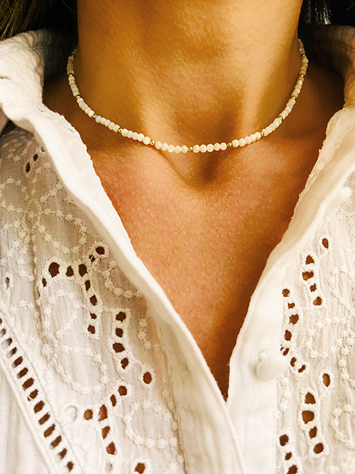 Gros plan collier élastique perles pierres naturelles nacre blanche plaqué or