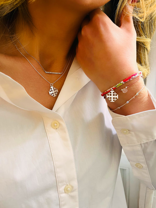 Gros plan colliers bracelets cordons argent chaînes croix de Jerusalem baguette zircons quartz rose perles