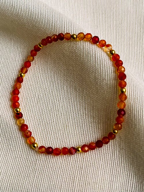 Gros plan bracelet élastique perles pierres naturelles cornaline plaqué or