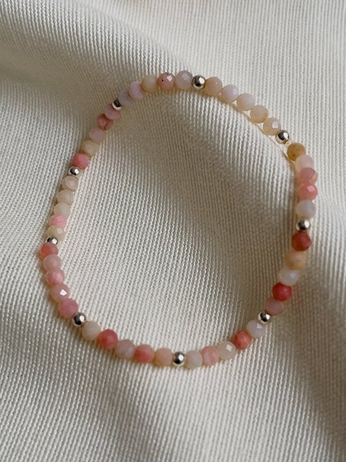 Gros plan bracelet élastique perles pierres naturelles opale rose argent