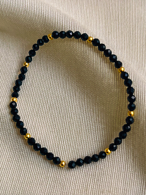 Gros plan bracelet élastique perles pierres naturelles onyx plaqué or