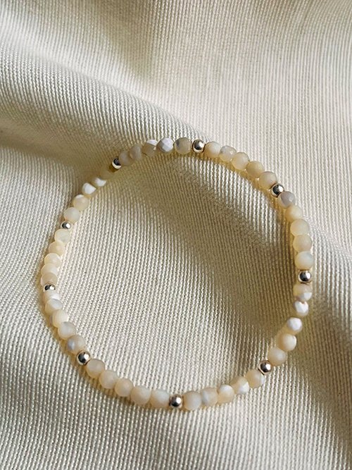 Gros plan bracelet élastique perles pierres naturelles nacre argent