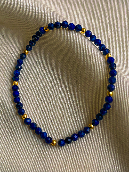 Gros plan bracelet élastique perles pierres naturelles lapis-lazuli plaqué or