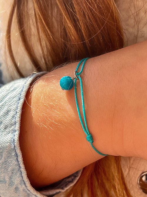Gros plan bracelet cordon pierres naturelles breloque Apatite Bleue Enfant