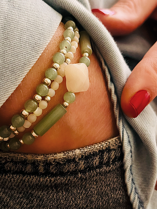 Gros plan bracelet élastique perles pierres naturelles aventurine nacre blanche trèfle argent