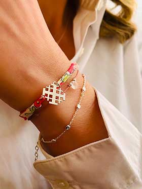 Gros plan bracelets cordons argent croix de Jerusalem quartz rose perles liberty