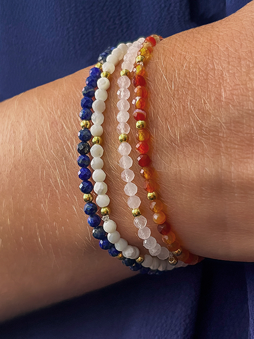 Gros plan bracelet élastique perles pierres naturelles nacre quartz rose lapis-lazuli cornaline plaqué or