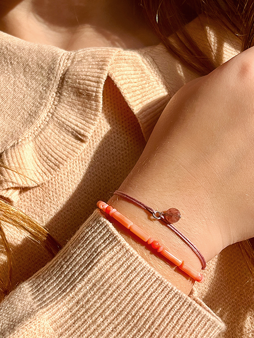 Gros plan bracelet élastique perles pierres naturelles Bambou de Mer cordon breloque Quartz Fraise Enfant