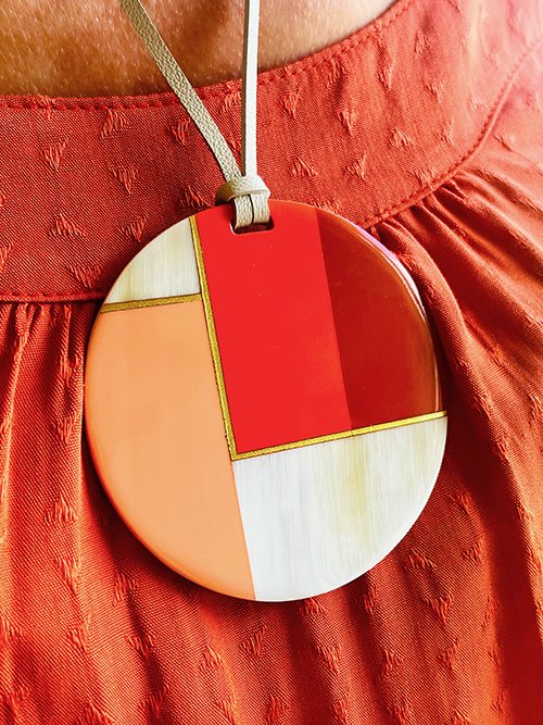 Très gros plan collier pendentif corne de buffle naturelle et 3 couleurs terracotta rose rouge cordon cuir