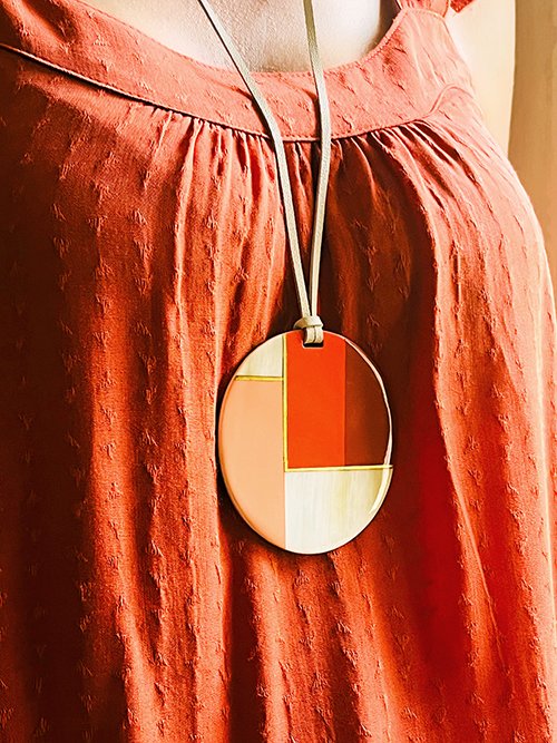 Gros plan collier pendentif corne de buffle naturelle et 3 couleurs terracotta rose rouge cordon cuir