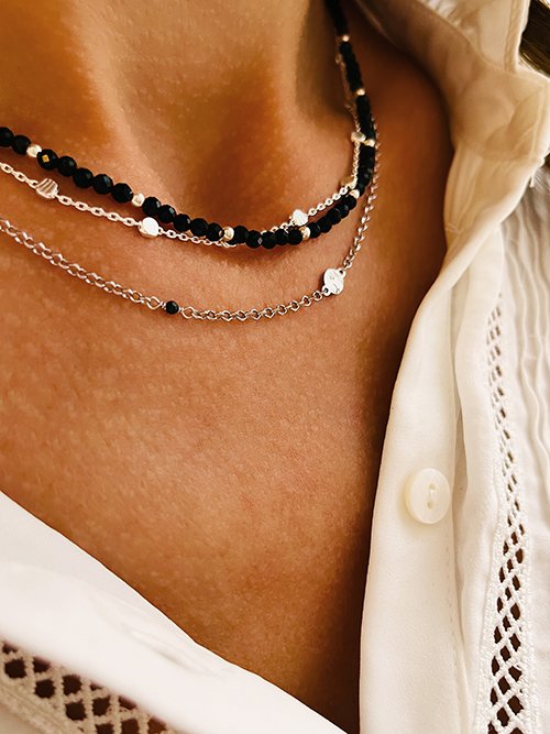 Très gros plan collier élastique perles pierres naturelles onyx argent chaine plaques martelées
